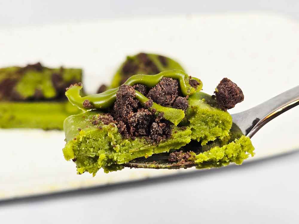 フォークですくった宇治抹茶ガトーショコラ。しっとりした断面とチョコクランチが見える。