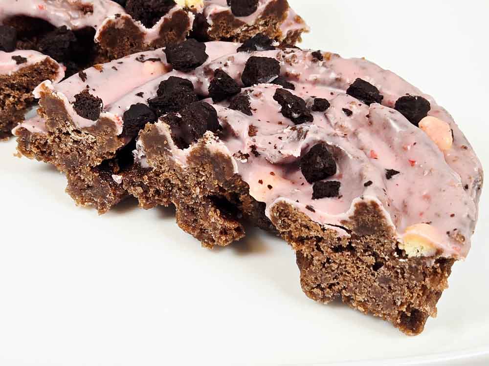 カットしたピンクなブラックサンダードーナツの断面。しっとりした生地とチョコの層が見える。